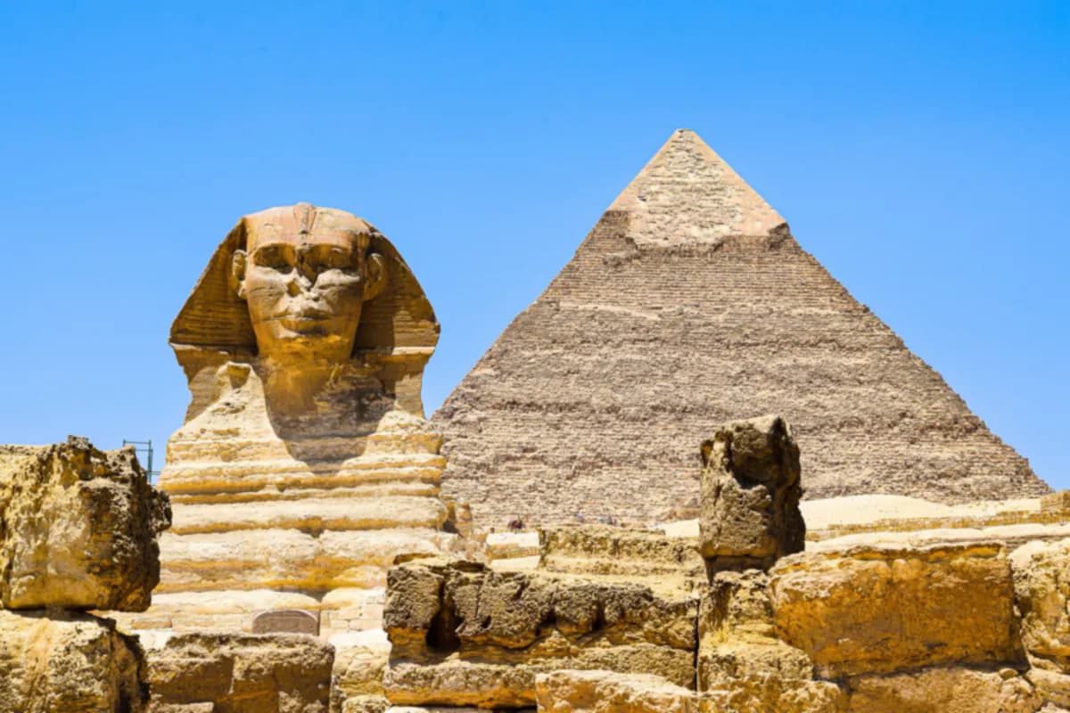 The Great Sphinx of Giza in front of the Pyramid of Khafre under a clear blue sky